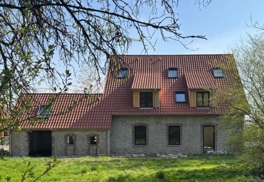 kleines Mehrfamilienhaus mit rotem Dach und Bruchsteinfassade